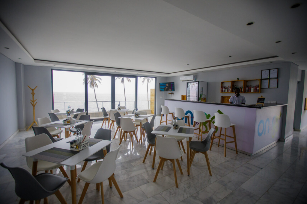 Sala do restaurante das CoWork Lab Suites, com bar e vista de mar