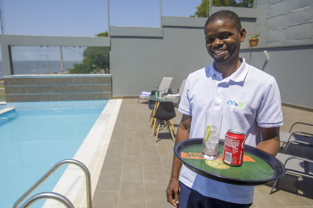 Empregado a servir bebidas junto à piscina das CoWork Lab Suites